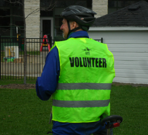 Man on bicycle with Steps for Life volunteer vest