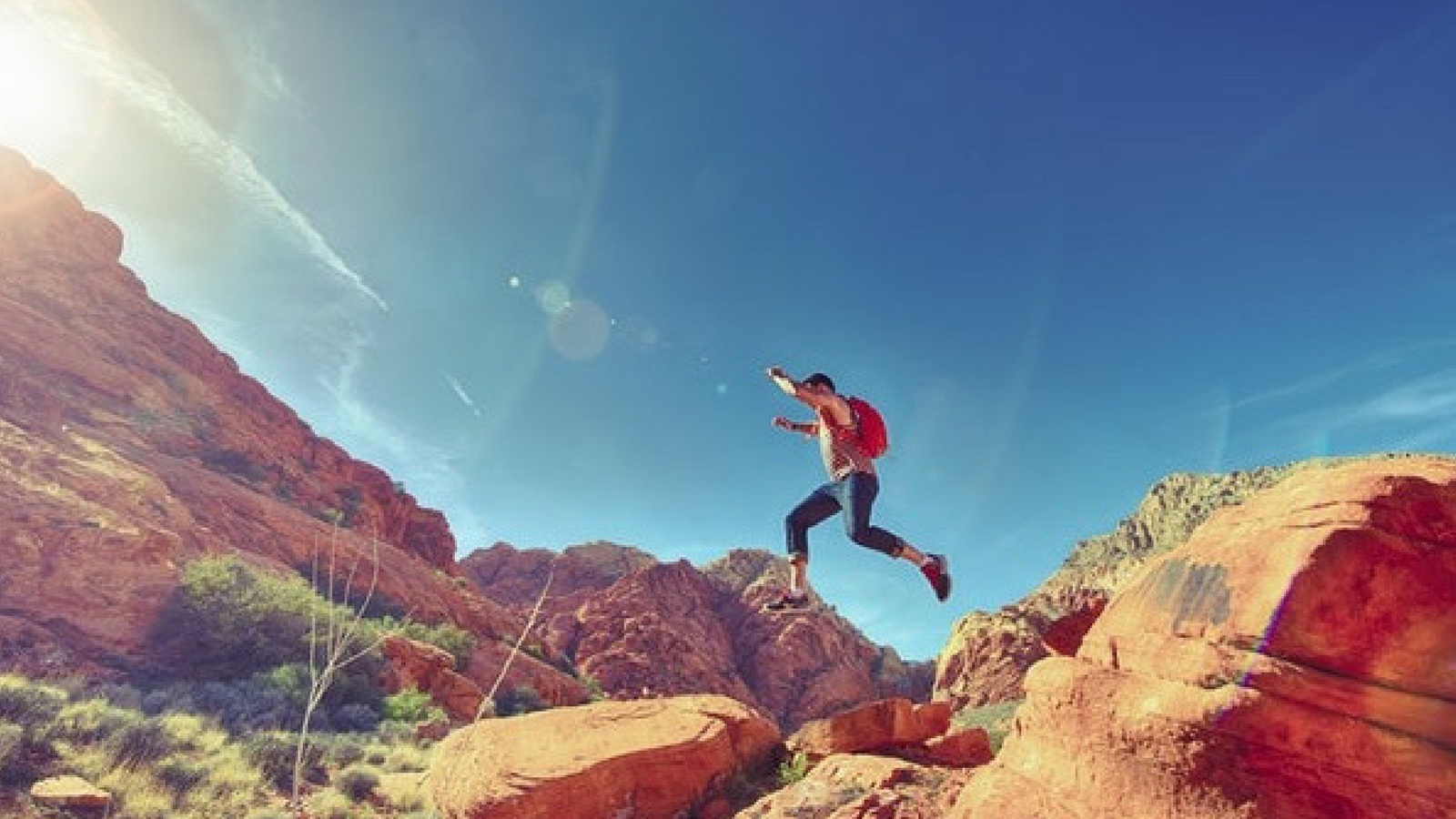 Man jumping through the air with desert landscape in the background