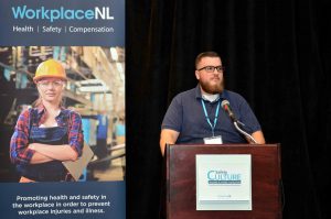 WorkplaceNL brochure cover on left and photo of man standing at podium wearing glasses and blue shirt