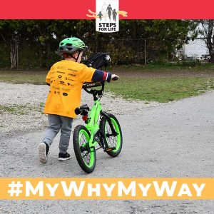 boy in yellow t-shirt walking his bike. #MyWhyMyWay