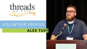 Volunteer Profile: Alex Tuff. Photo of man with beard standing at a podium