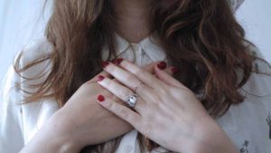 closely cropped image of woman's hands crossed over her chest
