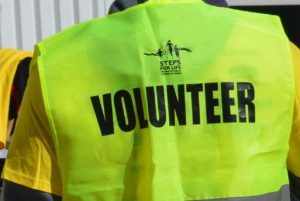 Back of fluorescent vest reads "Volunteer"