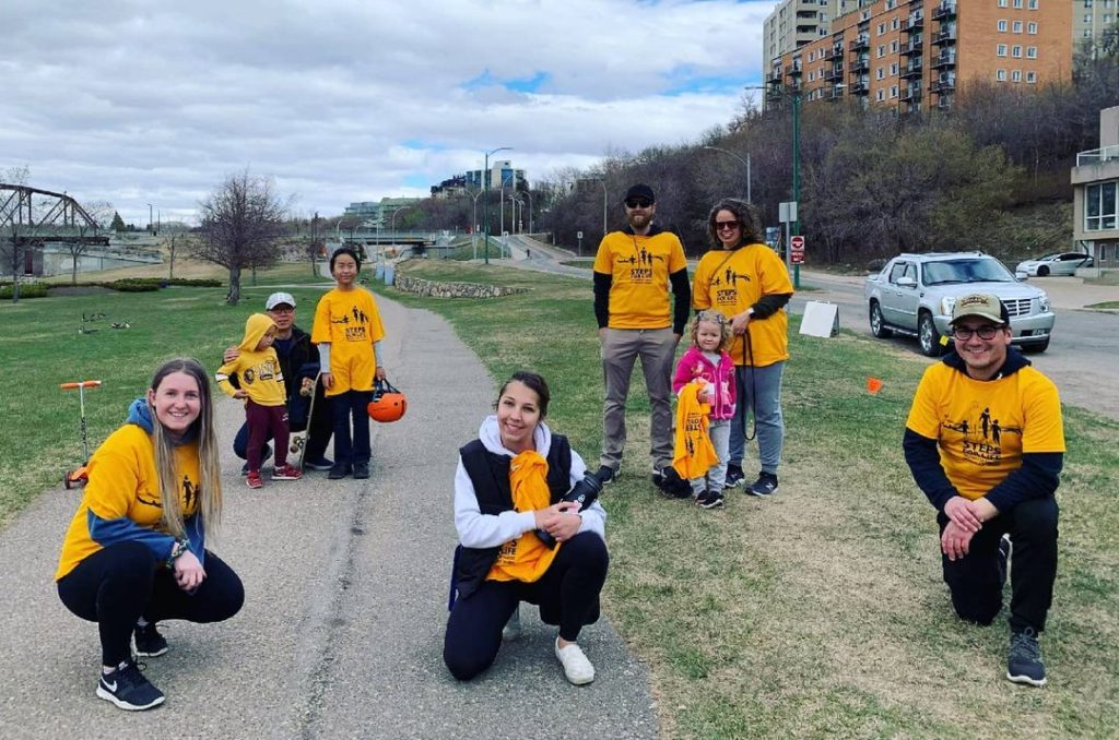 Seven Steps for Life walkers pose in yellow t-shirts, while maintaining social distance