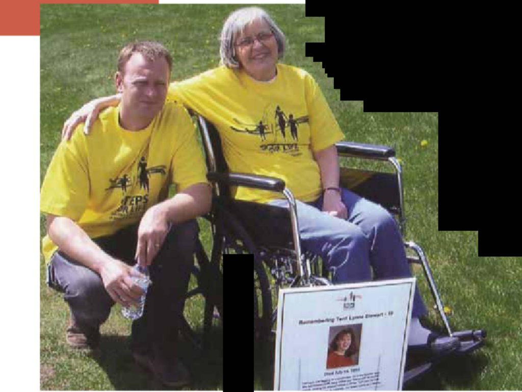 Man sits crouched beside woman in wheelchair