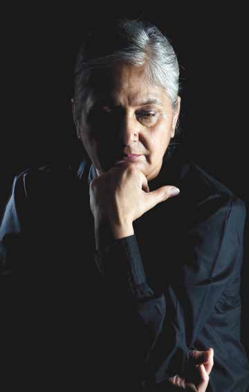 woman with grey hair glancing downward. Her face is in shadow.