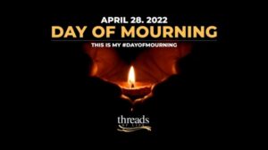 A pair of hands cup a lit candle. Surrounded by darkness, the glow of the light forms the shape of a heart. The text reads "April 28, 2022 Day of Mourning. This is my #DayOfMourning.
