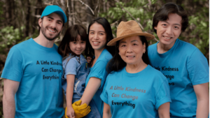 A group of people wearing blue t-shirts that read "a little kindess can change everything"