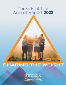 Cover reads "Threads of Life Annual Report 2022: Sharing the Weight". The central image is of a group of four people - presumed to be family or close friends - gathered arms over shoulders and looking off into a sunset. The sun is very bright and obscuring their features.