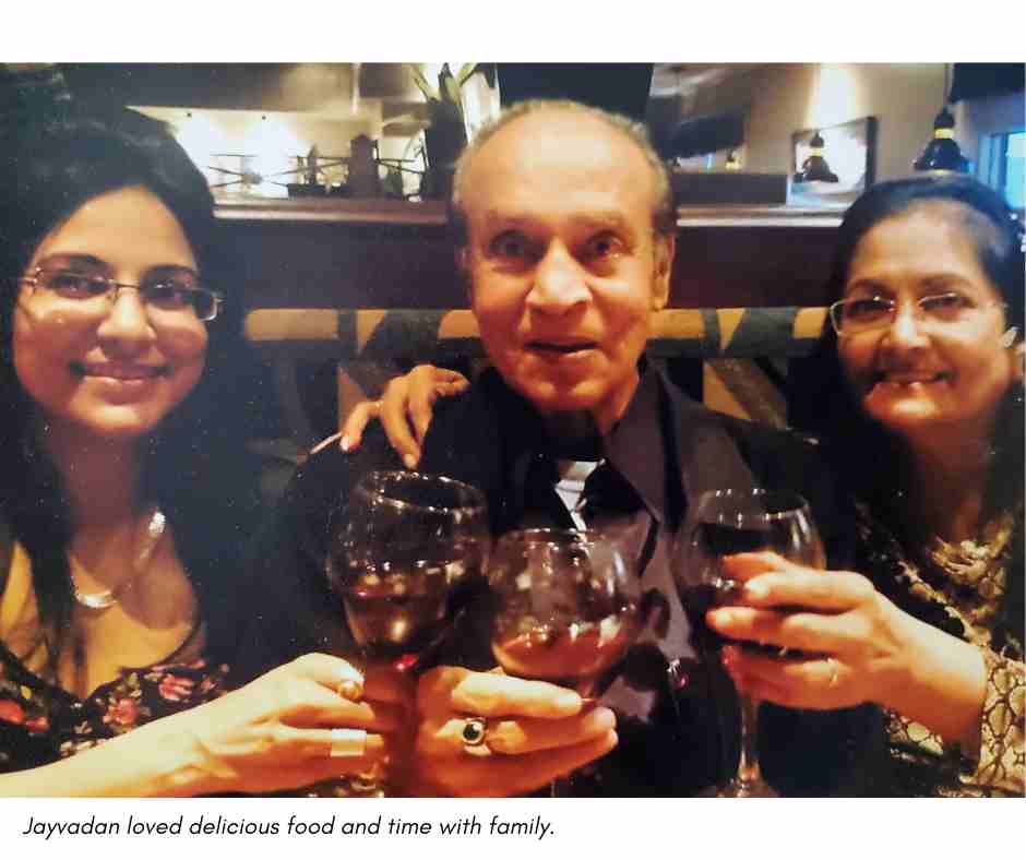 Jayvadan, his daughter and his wife raise a glass of wine from a restaurant booth. The caption reads "Jayvadan loved delicious food and time with family."